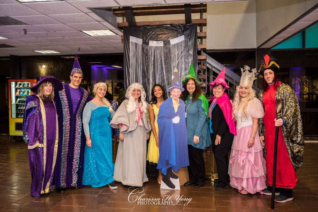 A group of adults wearing costumes for a magic theme night.