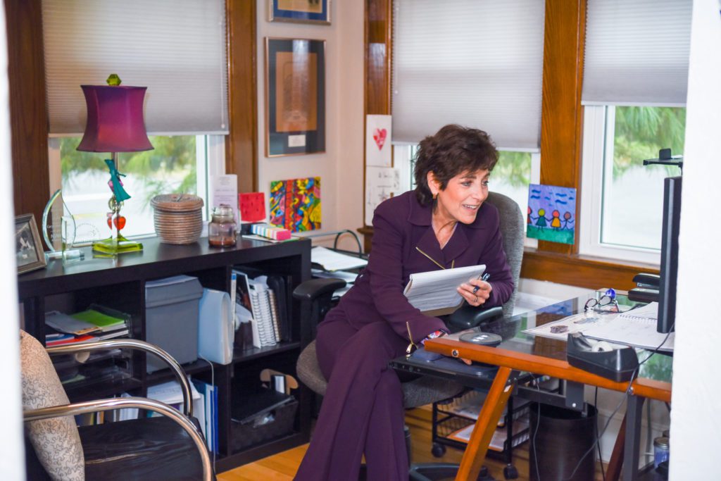 A woman working on a copywriting project on her computer in her home office.