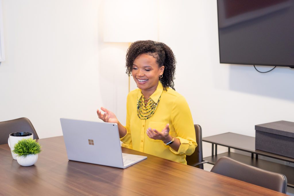 An African American woman talking on a video conference.