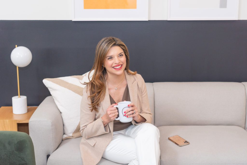 A female social media manager sitting and enjoying her cup of coffee.