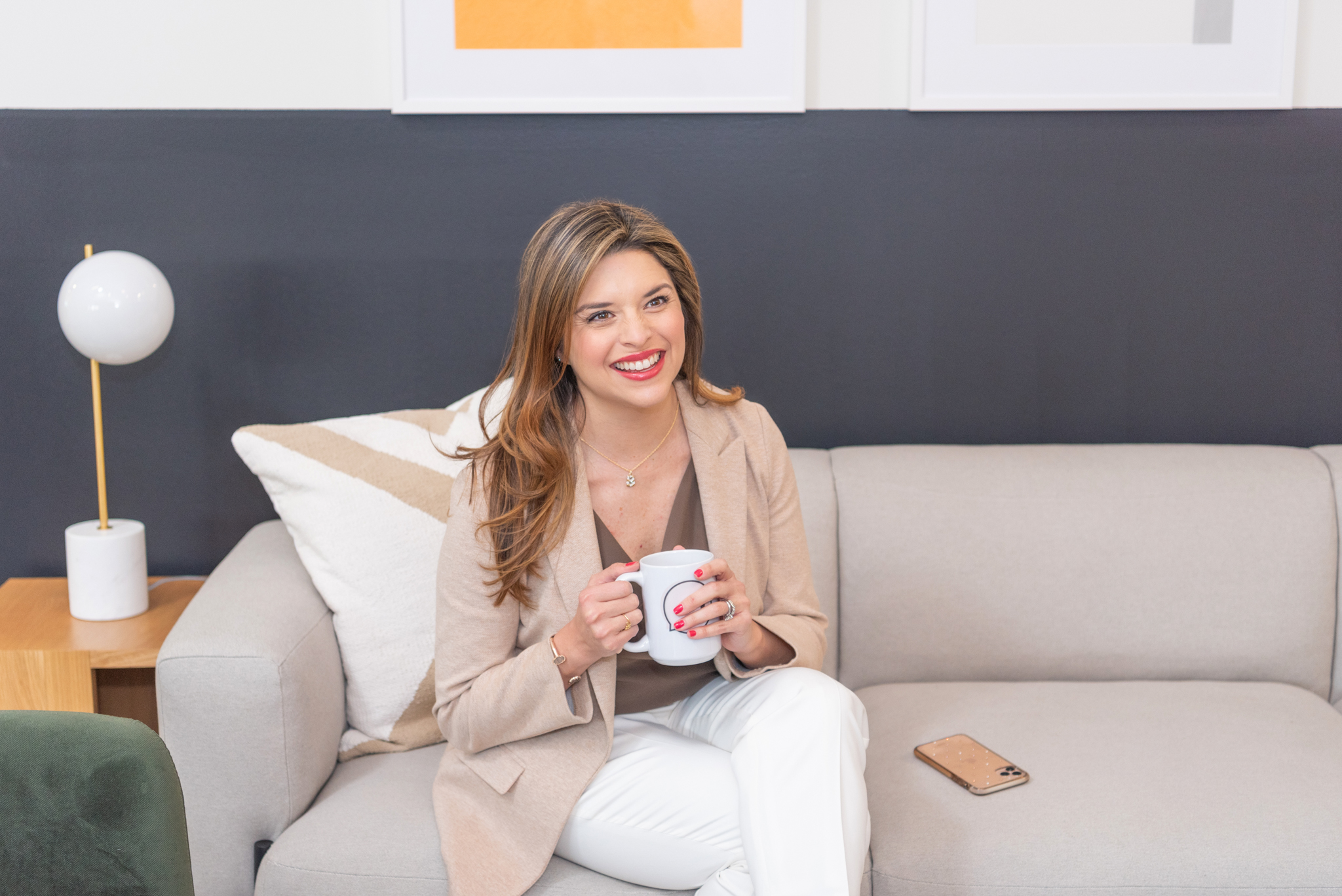 A female CEO sitting and laughing with her coffee.