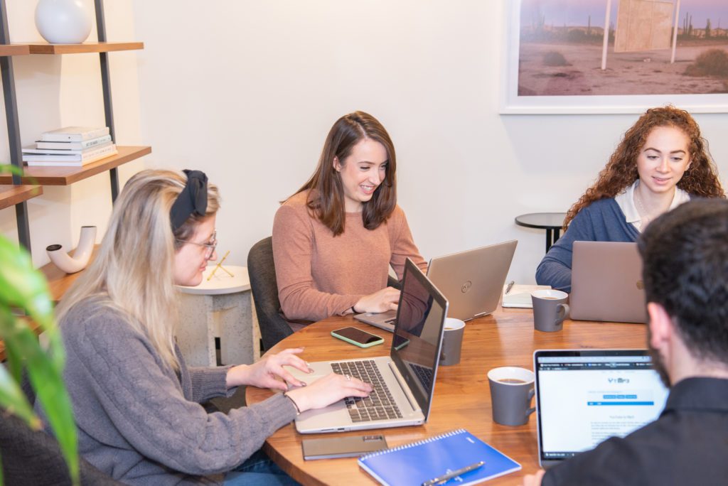 A team of marketing specialists working on their laptops in a conference room.