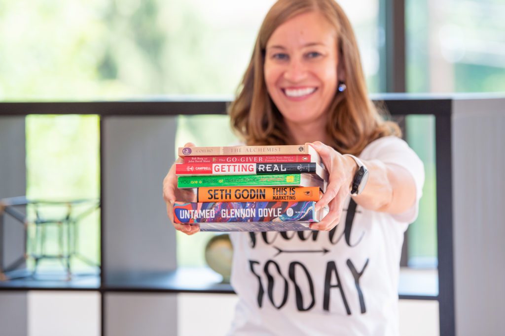 A female coach is showing off her favorite books.