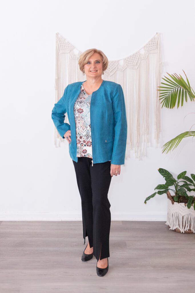 A female health and wellness coach standing and posing for her headshot.