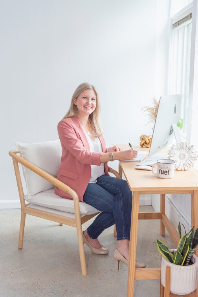 A female business coach smiling and working in her office.