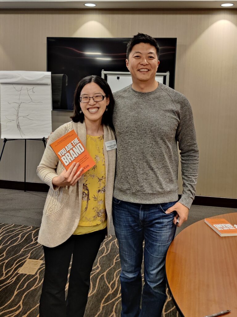 Charissa H. Yong is holding the You Are The Brand book and standing next to the author of the book, Mike Kim.