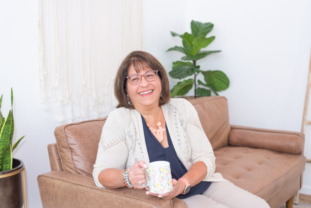Susana Fonticoba of Clear Path Strategy sitting on the couch with her mug.