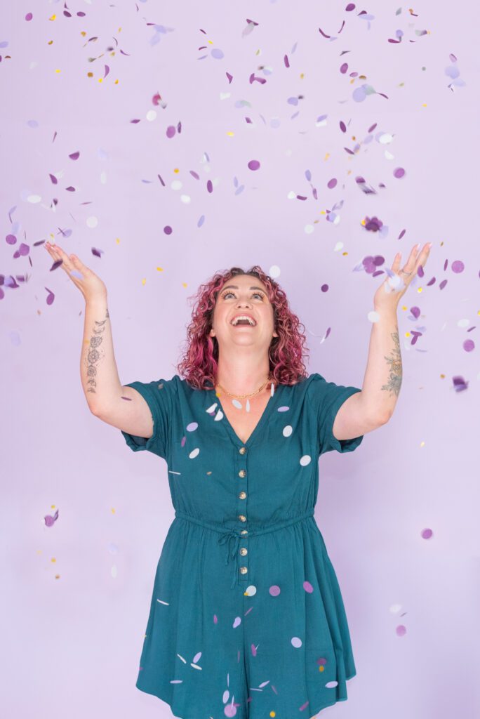 A female New Jersey cottage baker throwing confetti in the air celebrating the launch of her business.