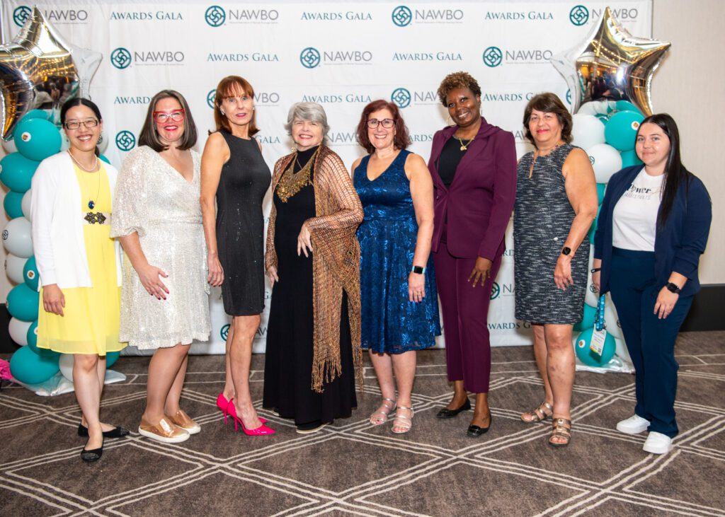 A group of women business owners standing in front of the NAWBO Awards Gala step and repeat banner.