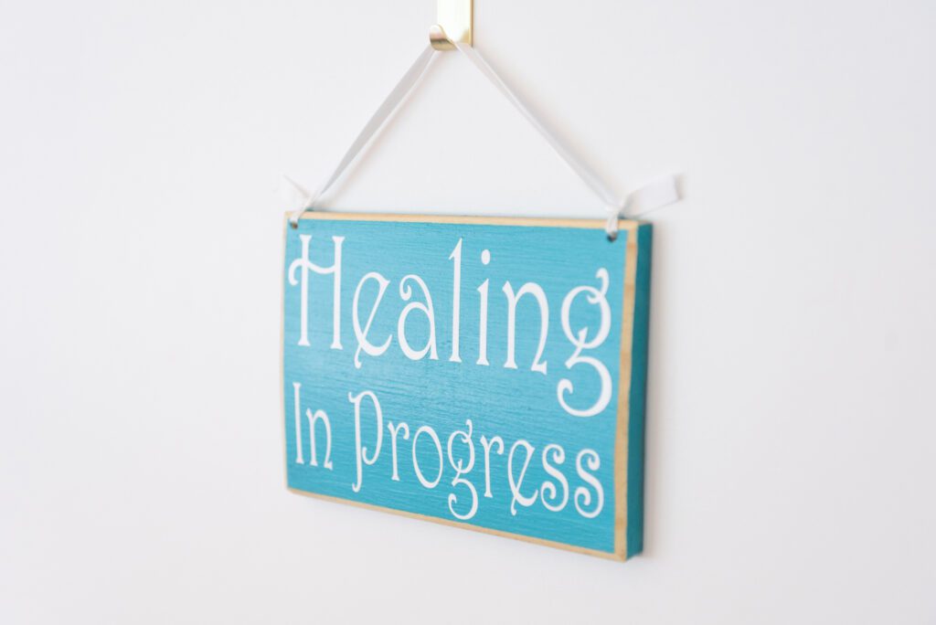 A "Healing in Progress" sign hang on a therapist door.
