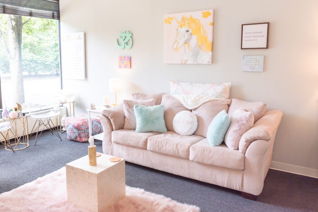 A female Clinical Social Worker and Therapist's office with a light pink comfy couch.