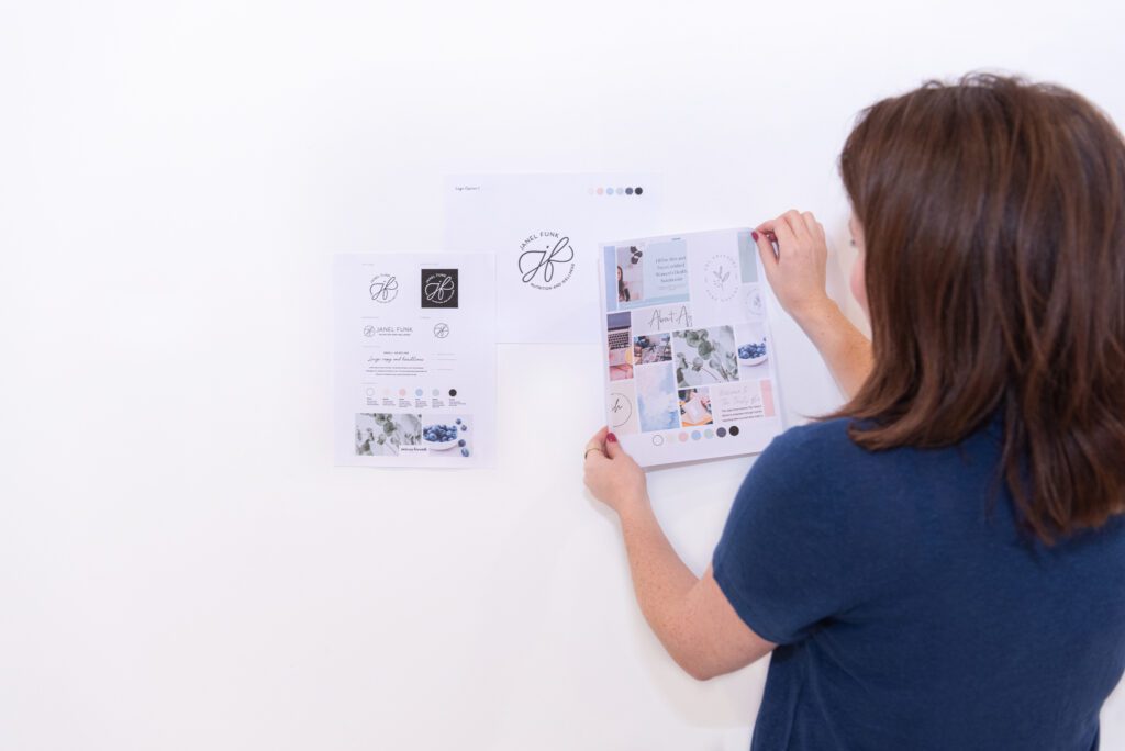 A female graphic and website designer planning out her client design on the white board.