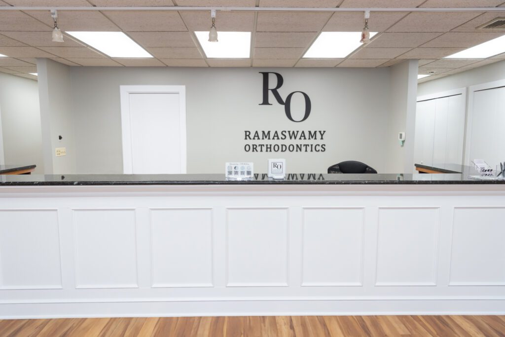 The front desk of the A sign at the Ramaswamy Smile Orthodontics office.