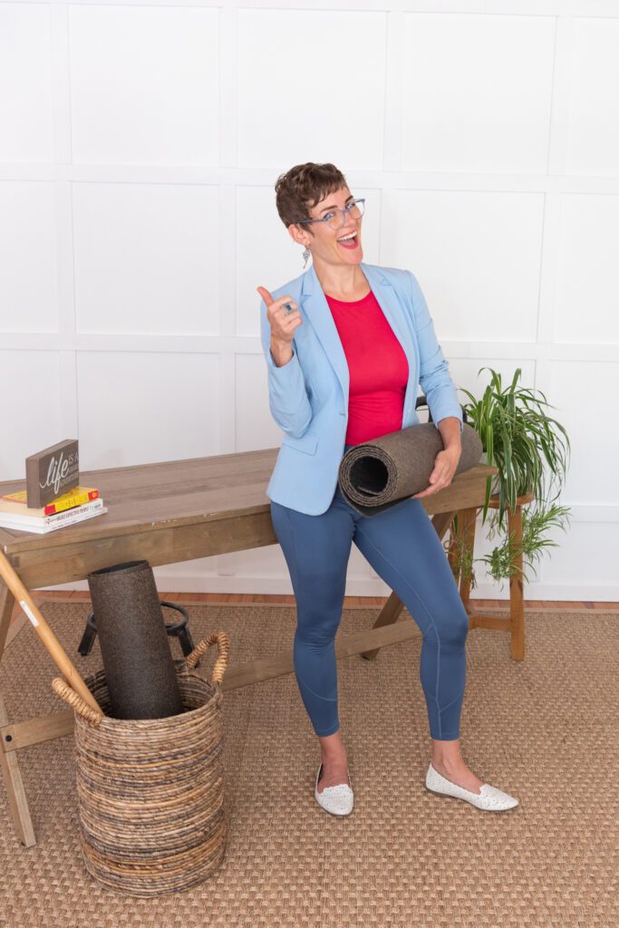 A woman holding a yoga mat getting ready for her yoga classes.