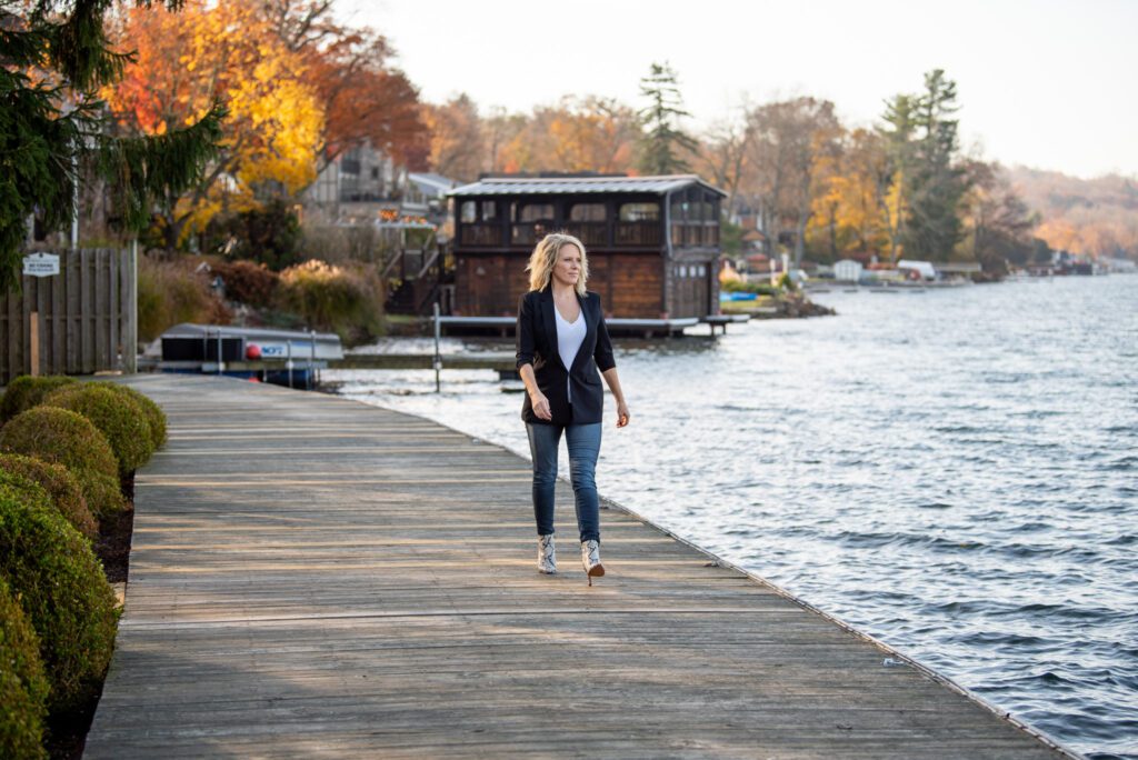 A woman walking along side a pier during fall season.