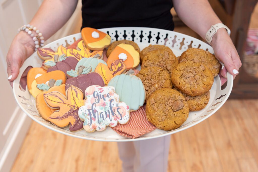 The owner of Treat Me Sweet Cookies in Ridgewood, New Jersey, holding a platter of Fall theme cookies.