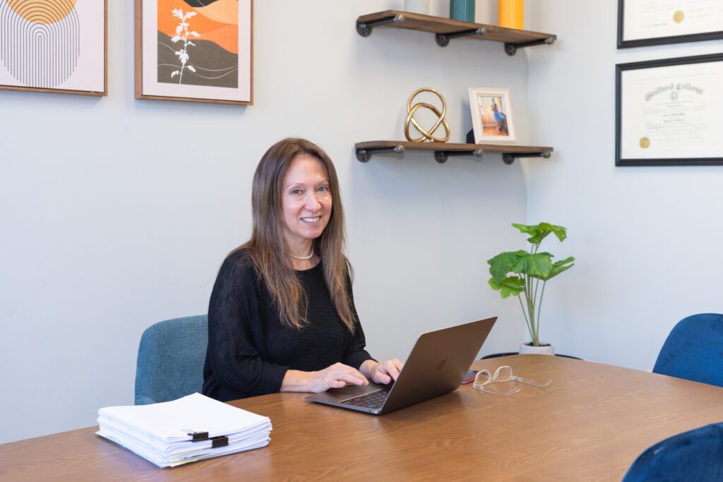 A female psychologist working on the laptop in her office.