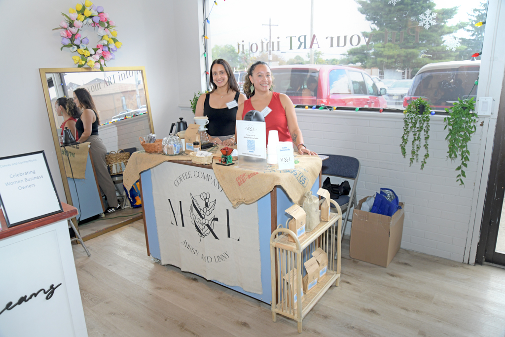 The owners of Missy & Linny Coffee Company standing and smiling at their station serving aromatic Columbian coffee at the Canvas & Connections: Celebrating Women Business Owners event at Moda Studio in Fairfield, NJ.