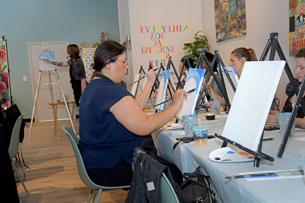 Attendees are enjoying painting a Fall theme canvases at the Canvas & Connections: Celebrating Women Business Owners event at Moda Studio in Fairfield, NJ.