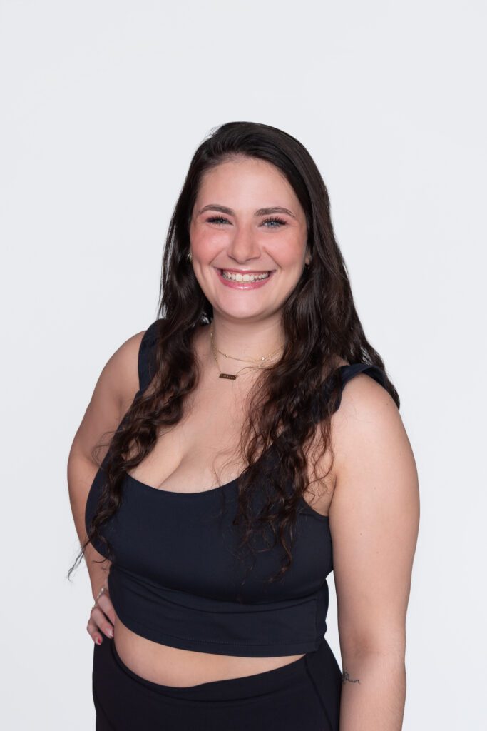 A female Pure Barre instructor smiling and posing for her headshot.