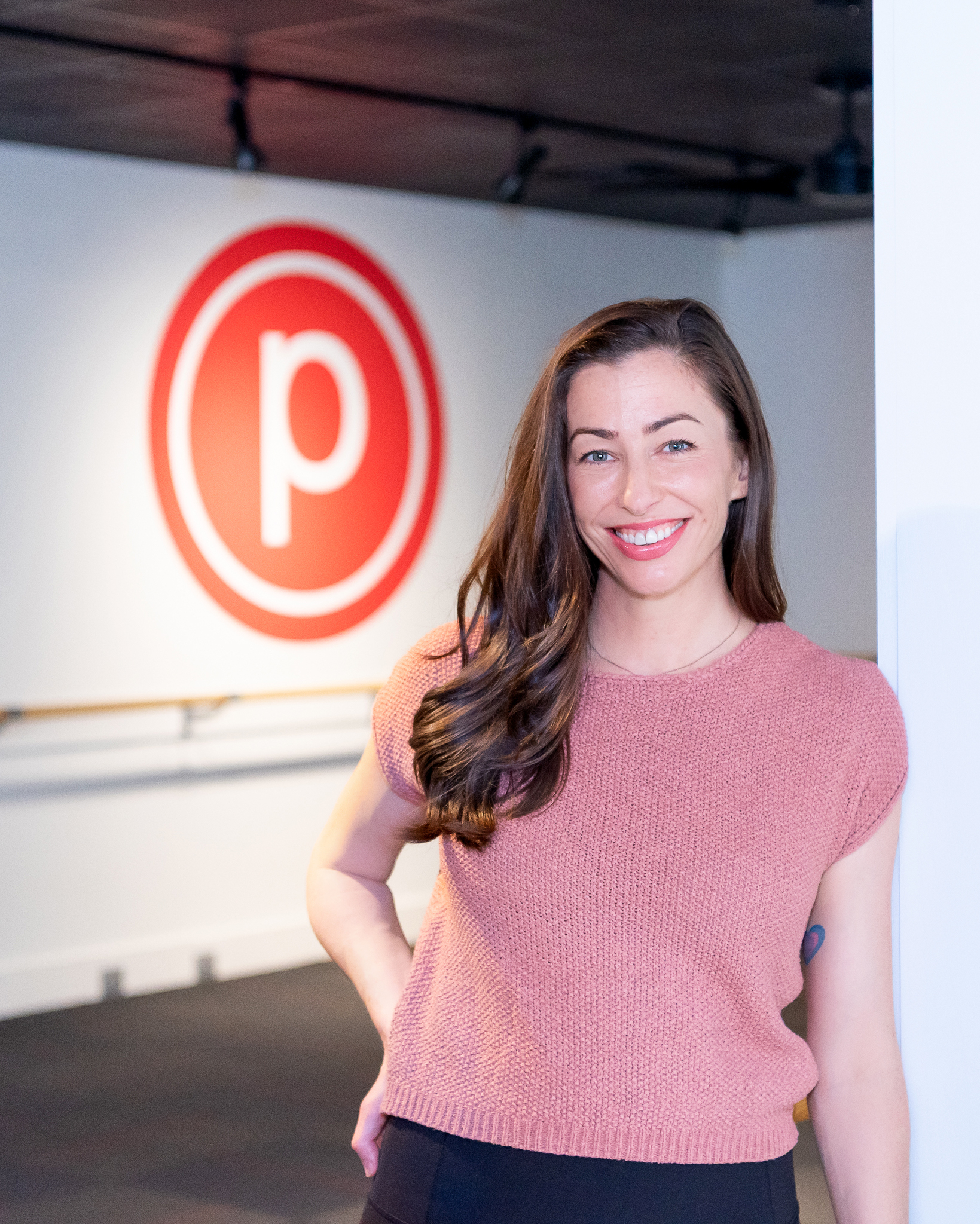 A female Pure Barre franchise owner smiling and posing for her headshot at her studio.