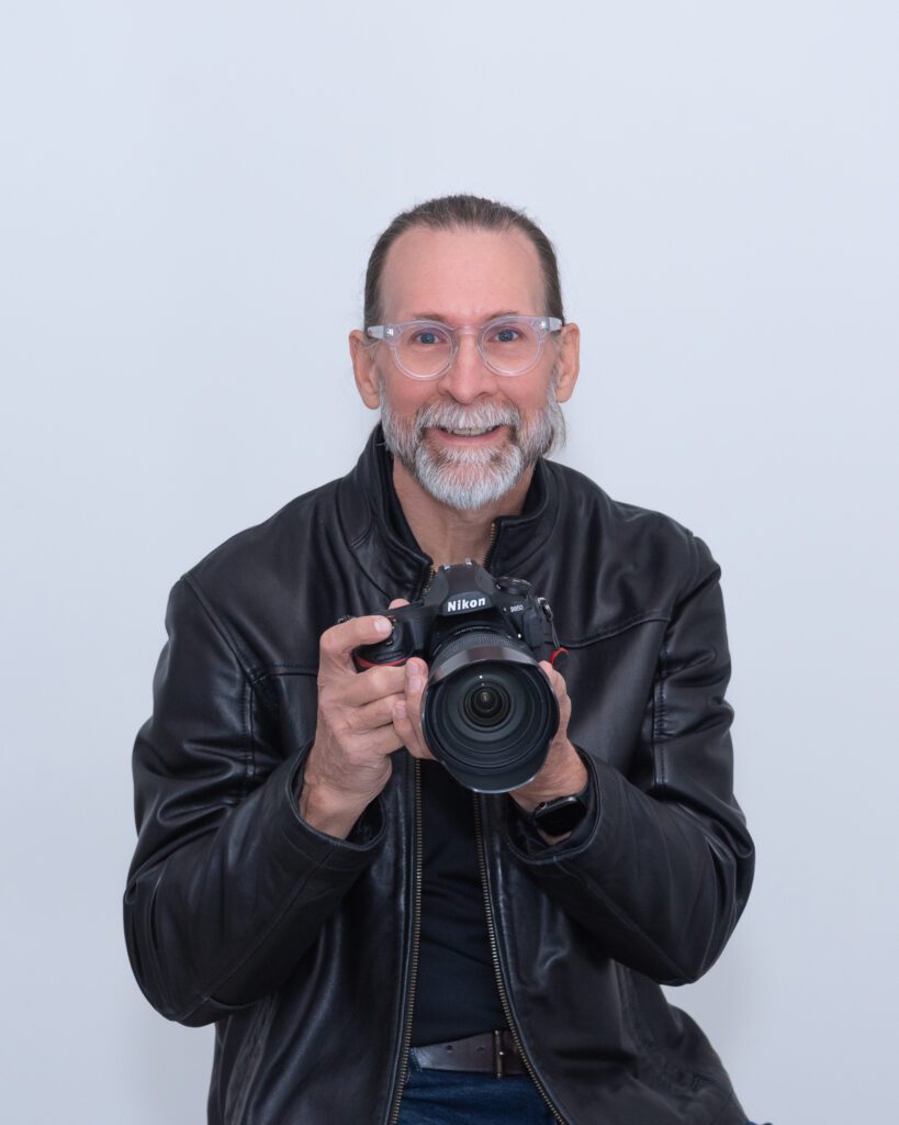 A male product and jewelry photographer holding his camera at his branding photo session.