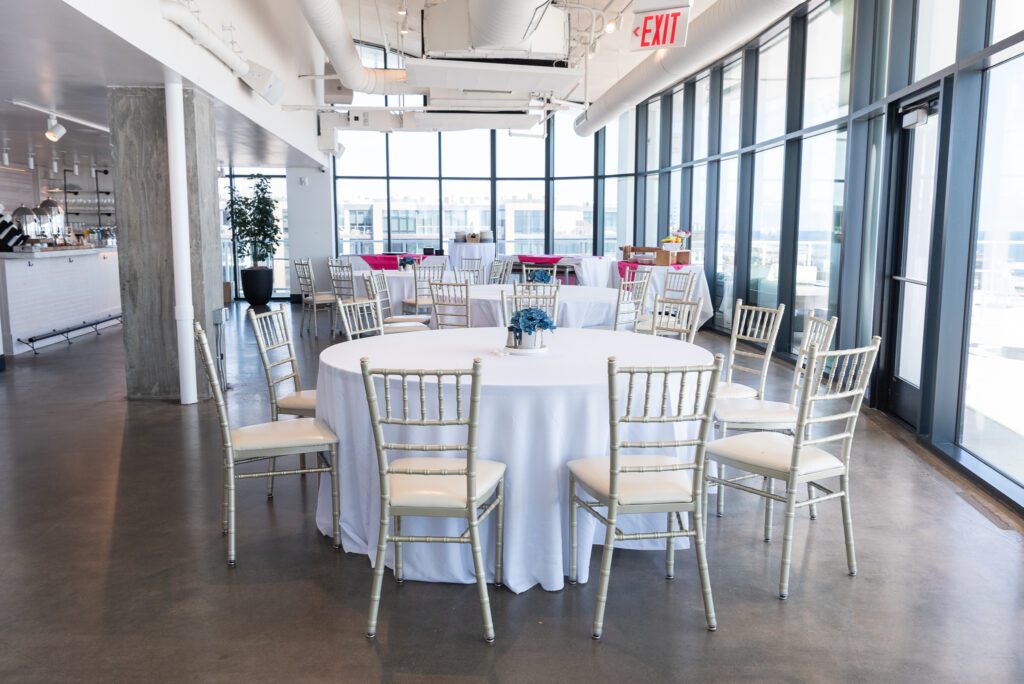 Wave Resort Long Branch event space with large windows and round tables and chairs.
