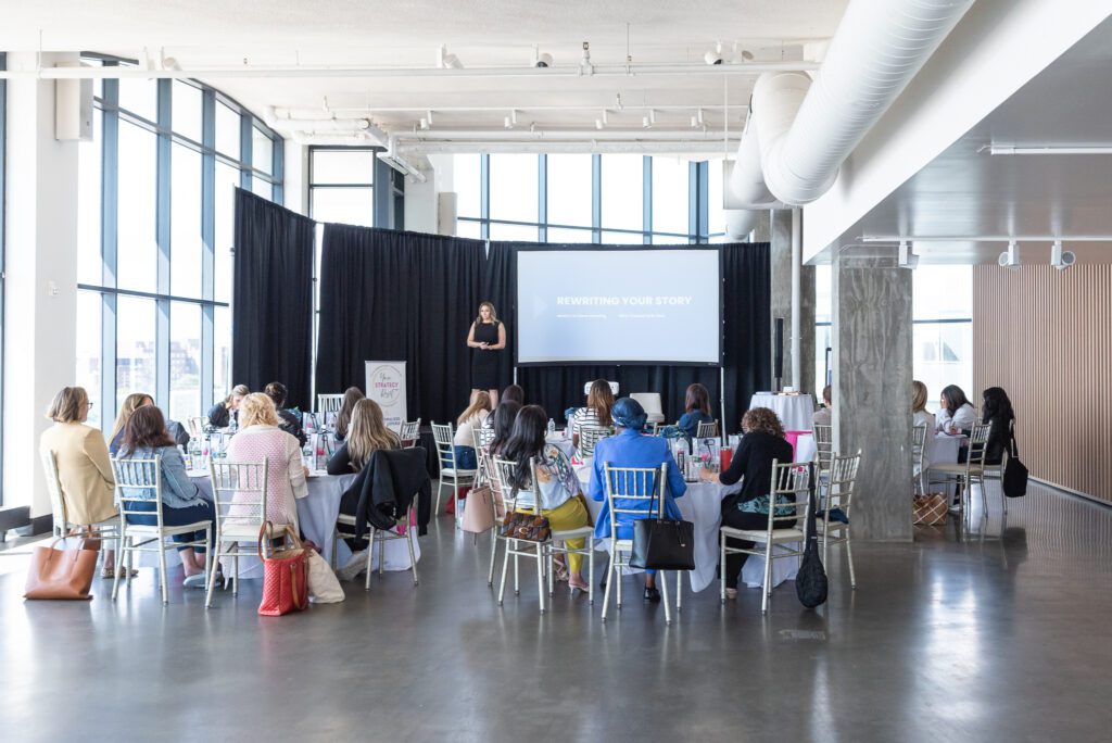 Attendees are sitting and listening to a speaker presenting at the Your Strategy Reset event in the Wave Resort.