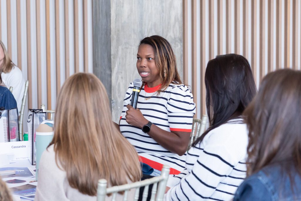An attendee holding a mic and talking at the Your Strategy Reset event in the Wave Resort.