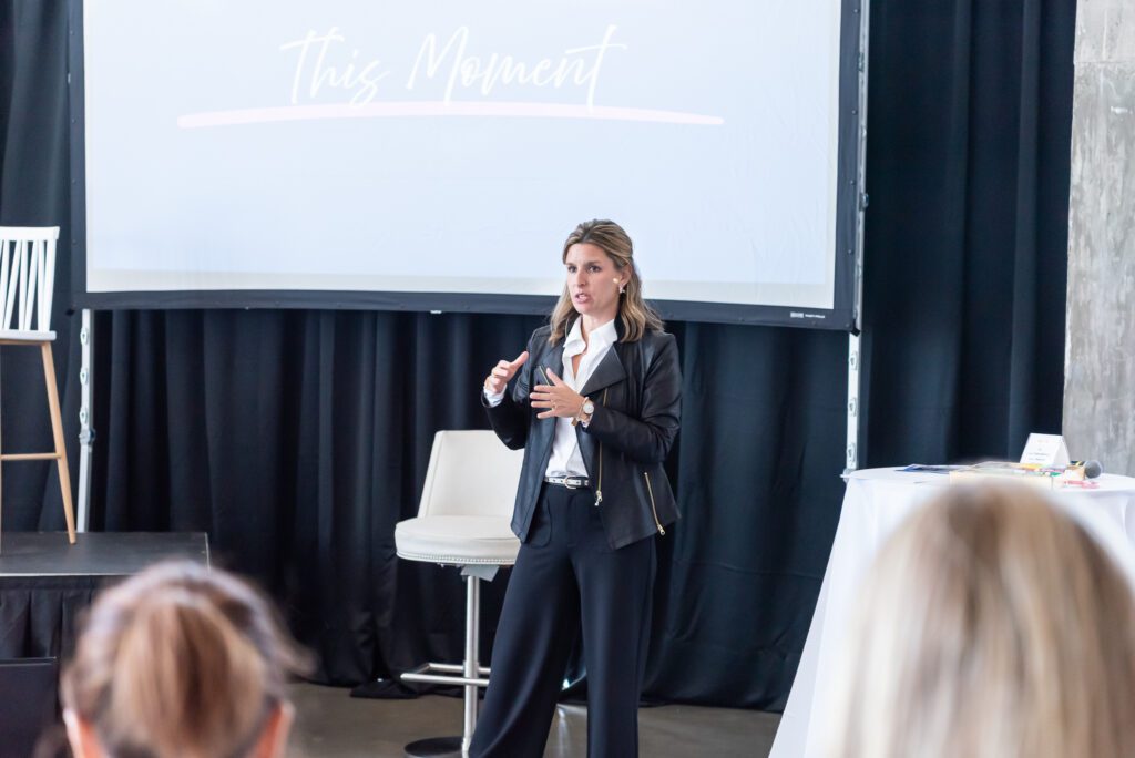 A coach and host speaking at the Your Strategy Reset event in the Wave Resort.
