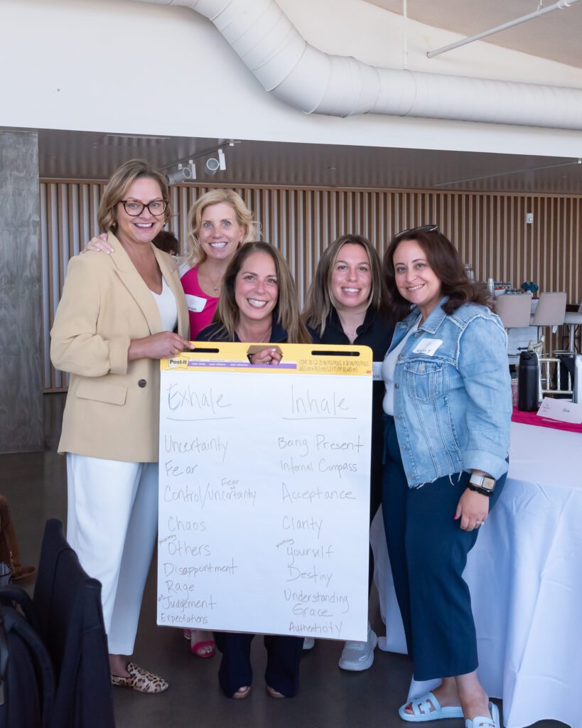 Five females pose for a photo with their work at the Your Strategy Reset event in the Wave Resort.