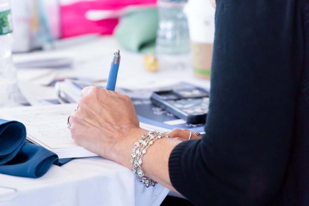 An attendee is writing at the Your Strategy Reset event in the Wave Resort.