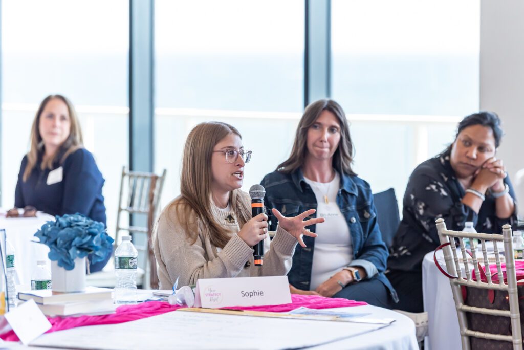An attendee holding a mic and talking at the Your Strategy Reset event in the Wave Resort.