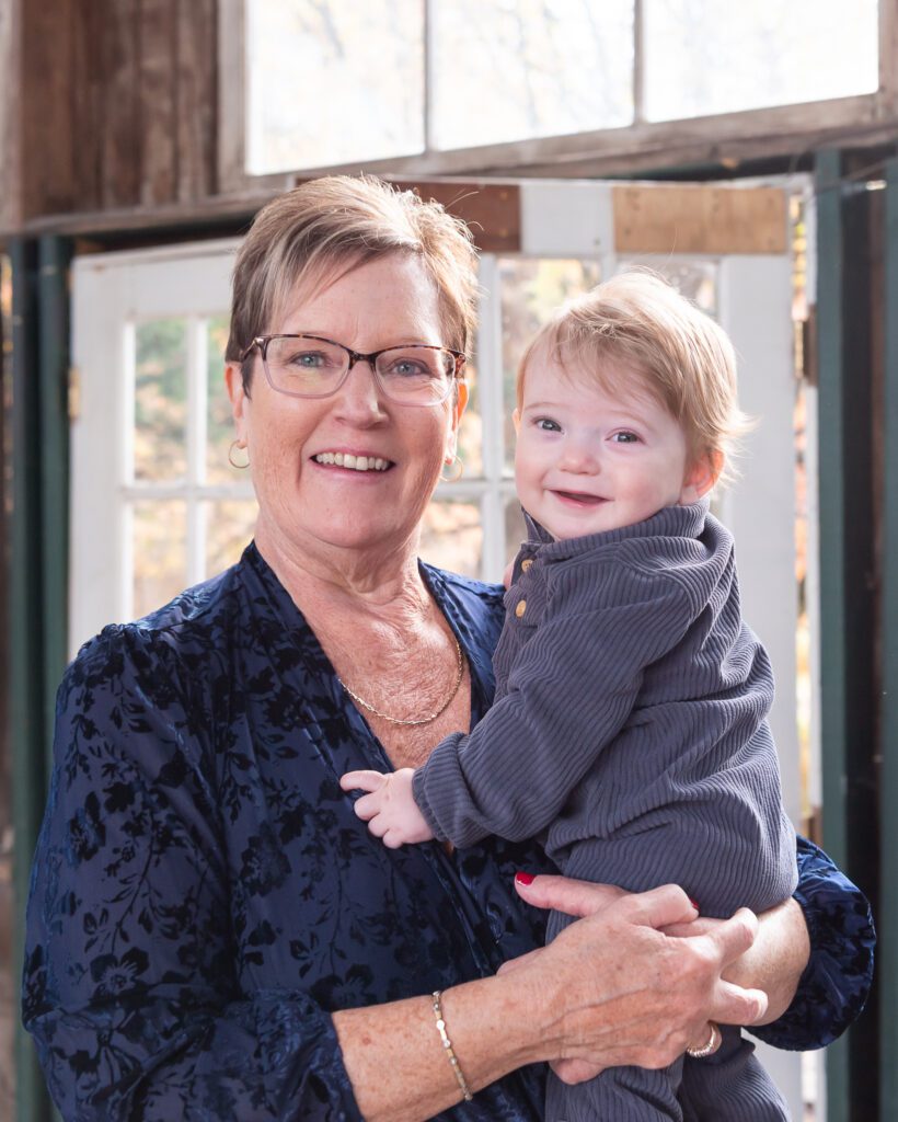 A grandmother holding her grandson smiling for their family photo session.