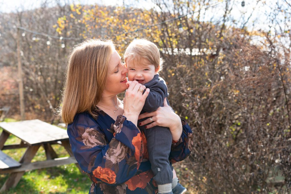 A mom gentling touching her nose on her son's face at an outdoor picnic area.