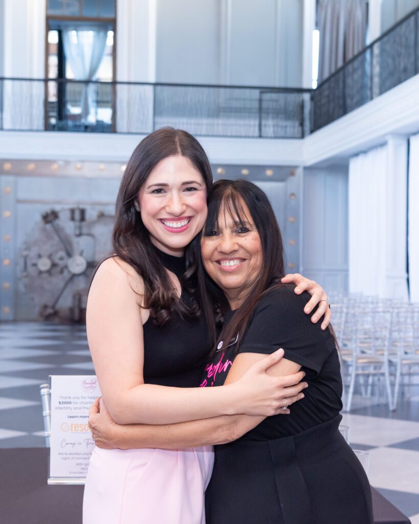 The female owner and host of the embroidery workshop posing and smiling for a picture with her mom at her event.