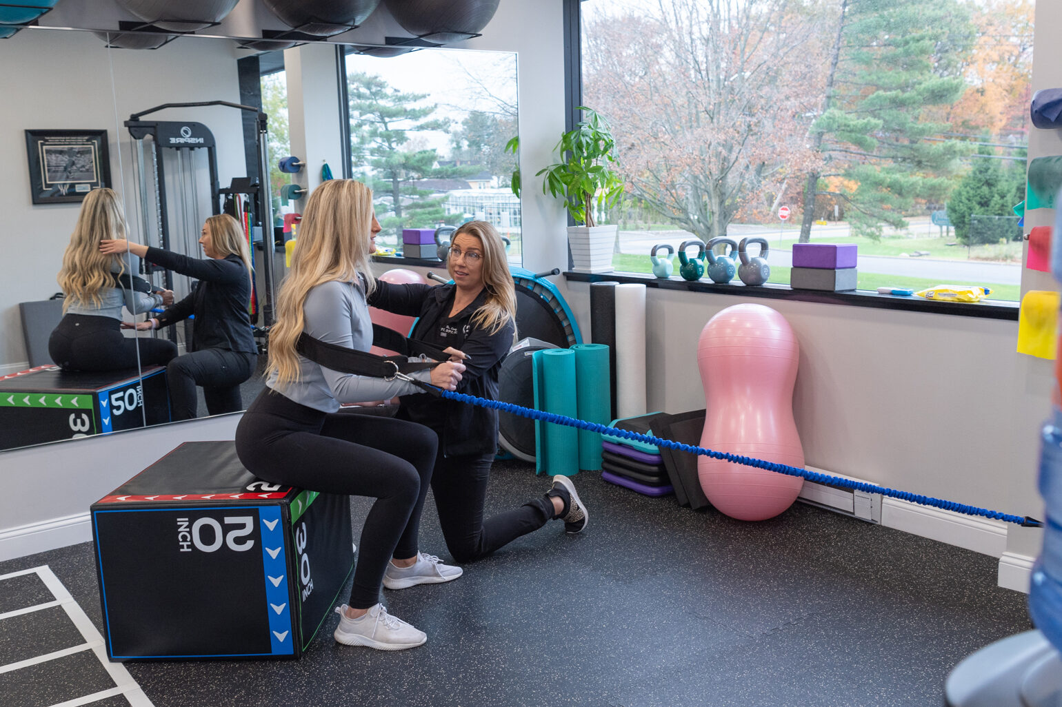 A female pelvic floor physical therapist working with a female patient in the workout room.