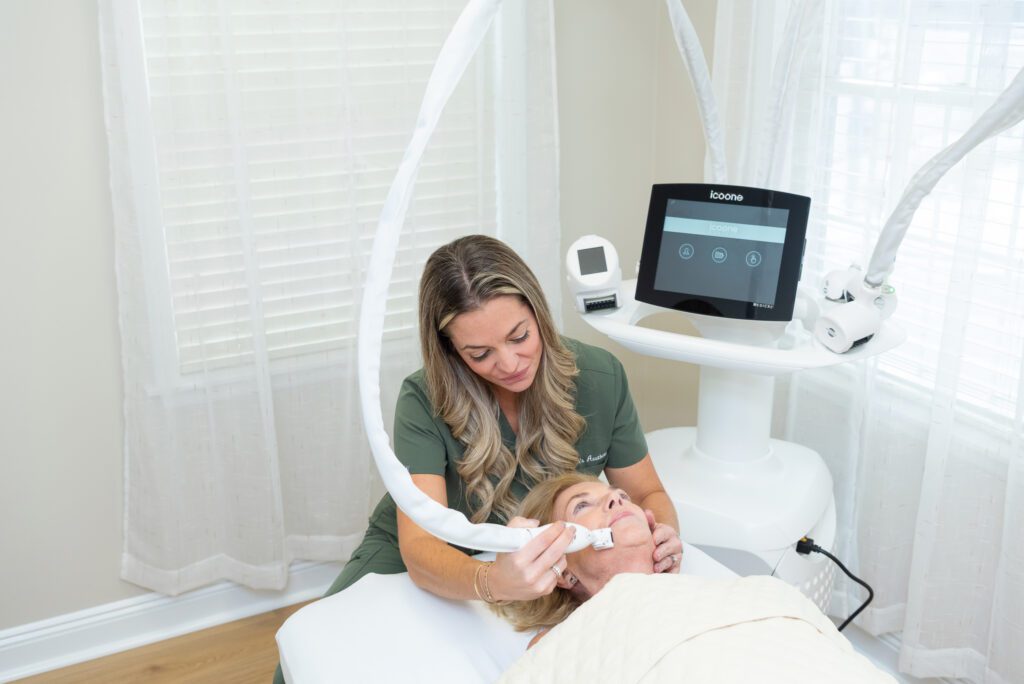 A female aesthetician doing an Icoone treatment on an elderly client.